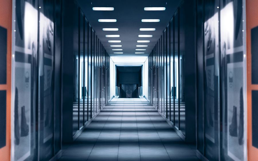 A cool-lit equipment corridor with a strong central perspective