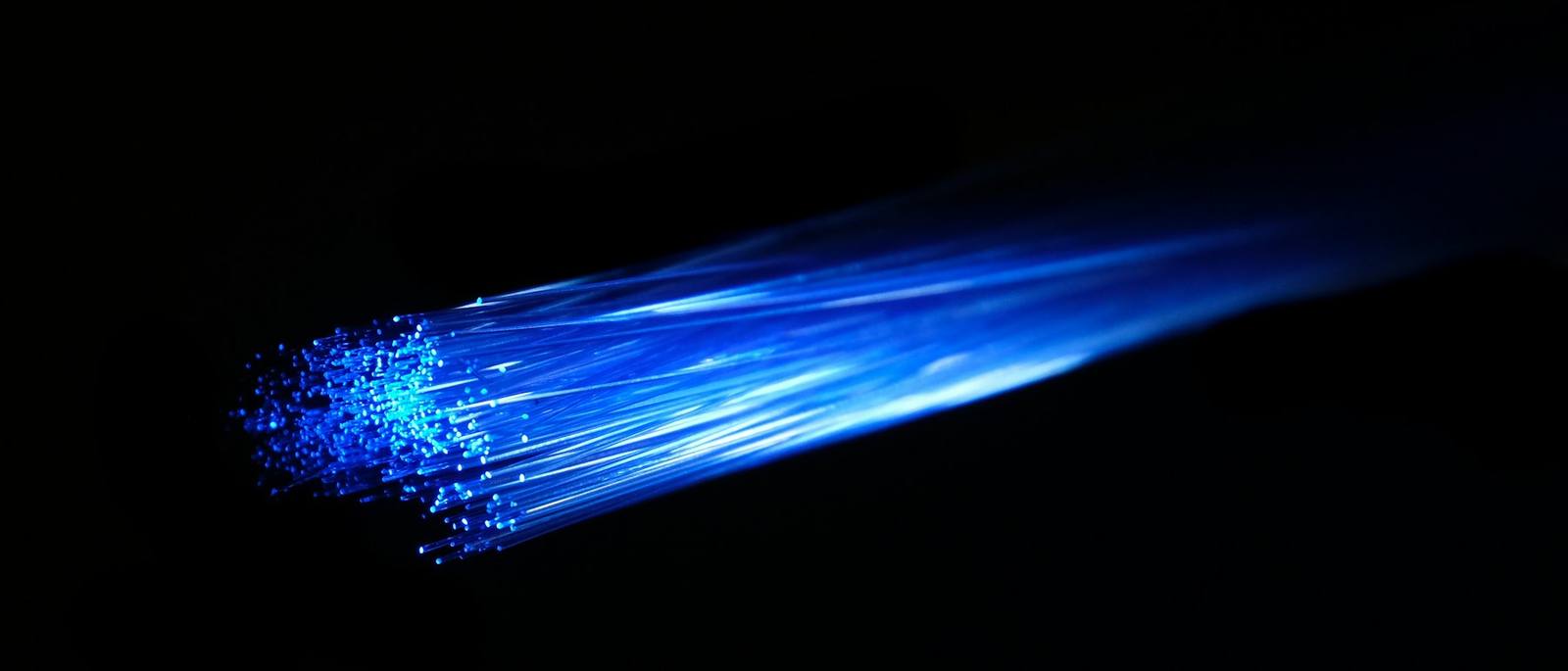A bundle of optical fibres trailing light across a black field