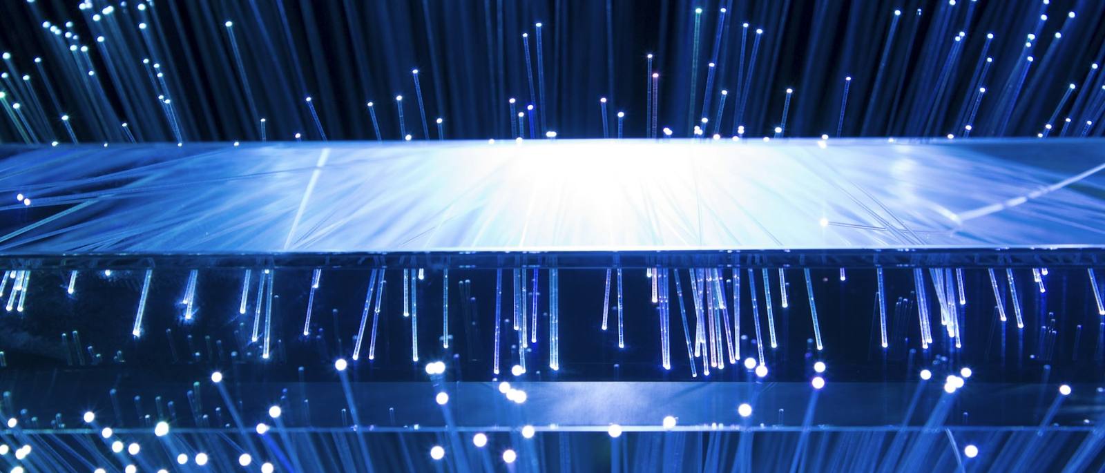 Optical fibres fanning out above and below a bar of light
